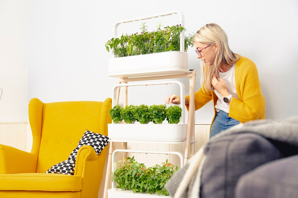 Girl tending to plants growing in a smart garden.