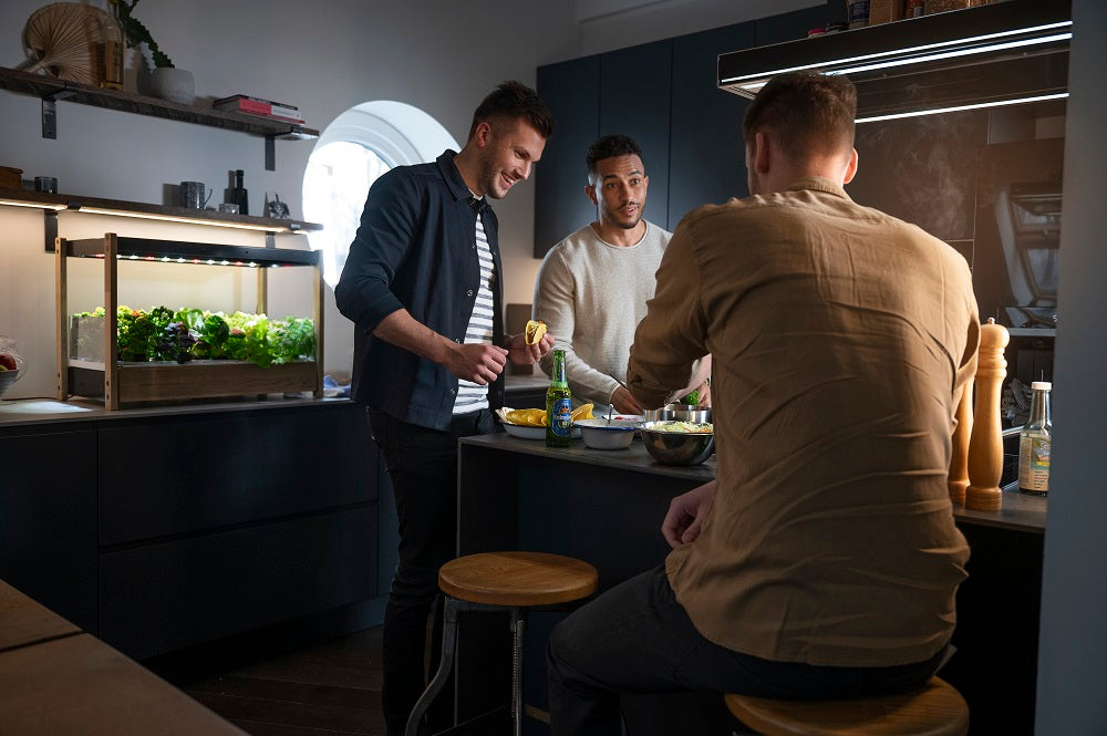 Men socializing with a Click and Grow 25 in the background.