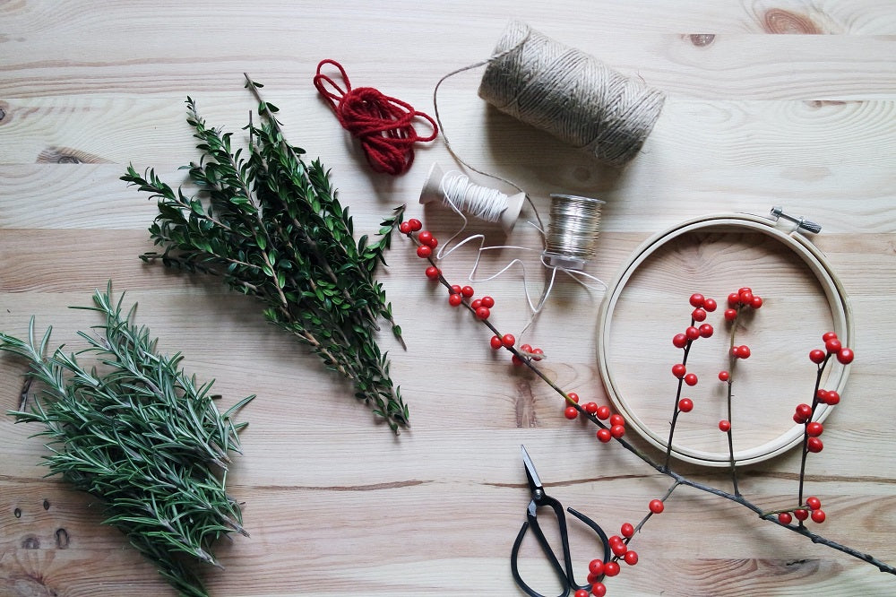 Herbs on a wooden table next to some string.