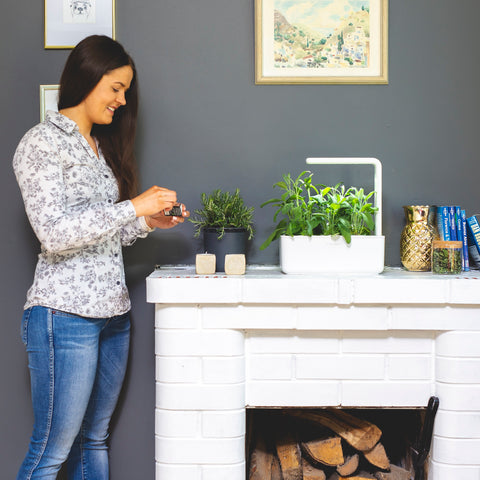 Woman standing next to a Smart Garden.