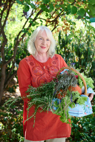 Portrait of a gardener carrying a basket full of plants.