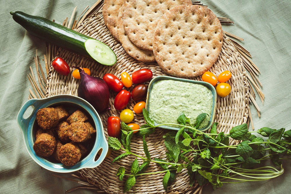 Pita bread and assorted vegetables on table.