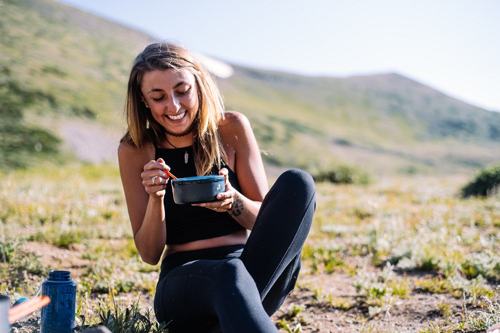 Happy woman enjoying a meal outdoors.