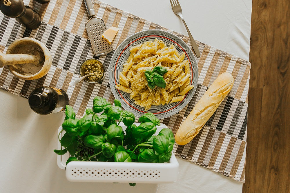 The smart garden 3 next to a pasta dish.