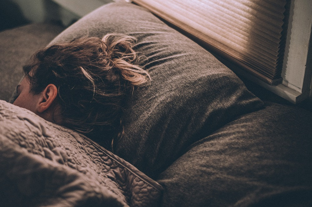 Woman sleeping under the covers in bed.