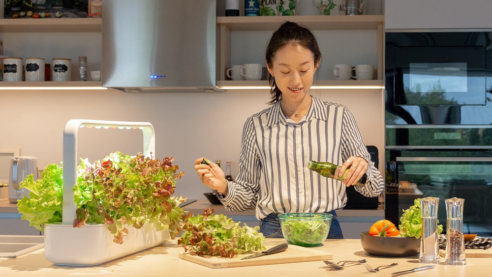 Woman making a meal from greens harvested from the Smart Garden 9.