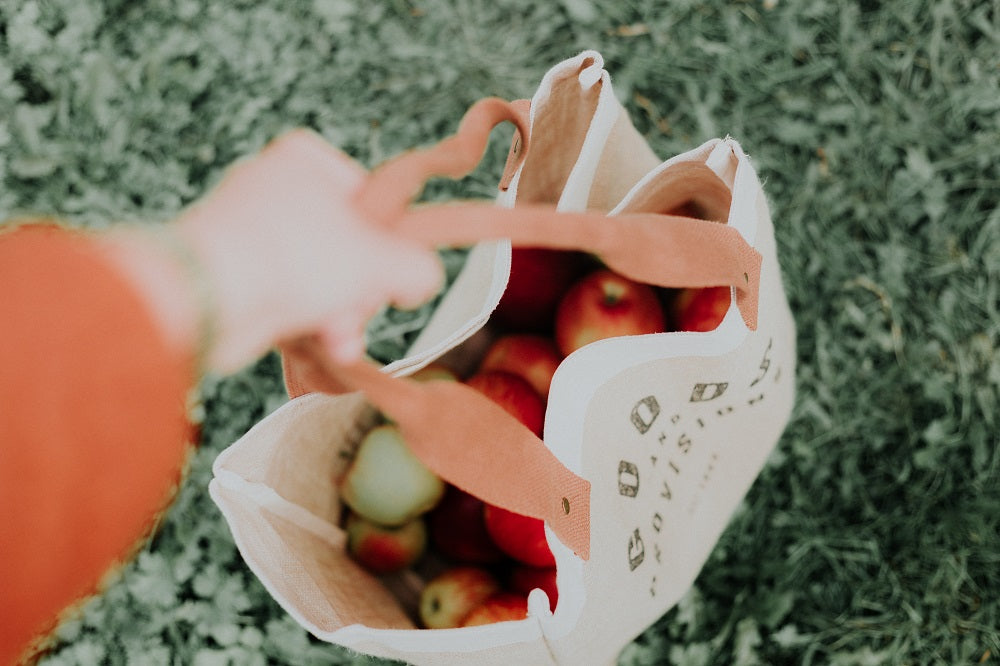 Reusable shopping bag full of apples.