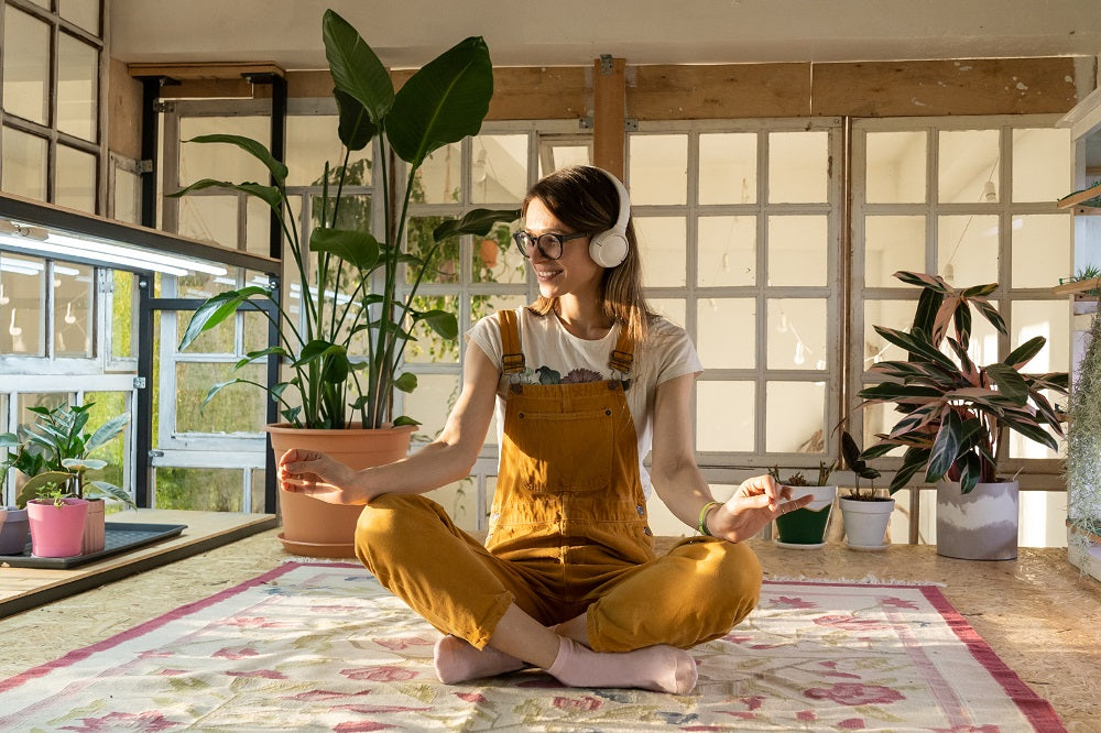 Girl meditating in a room with plants