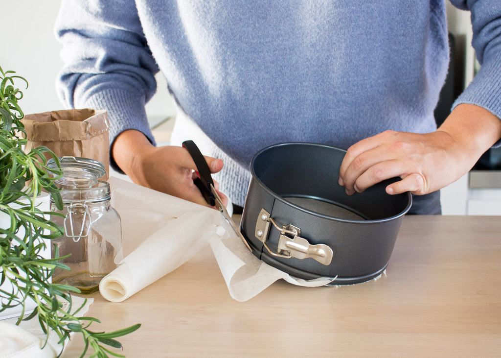 Woman cutting parchment paper for baking.